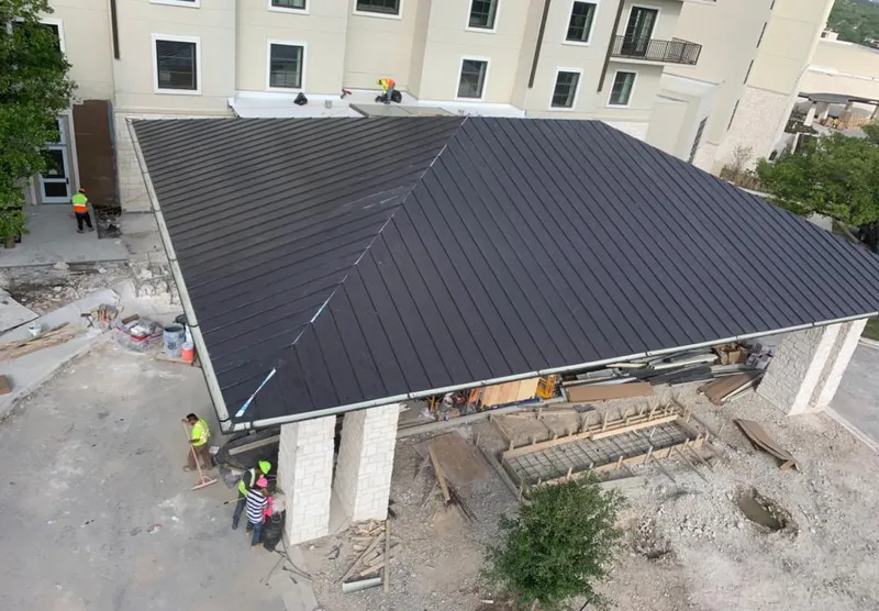 Metal roofing installation team working on a commercial building in Modesto